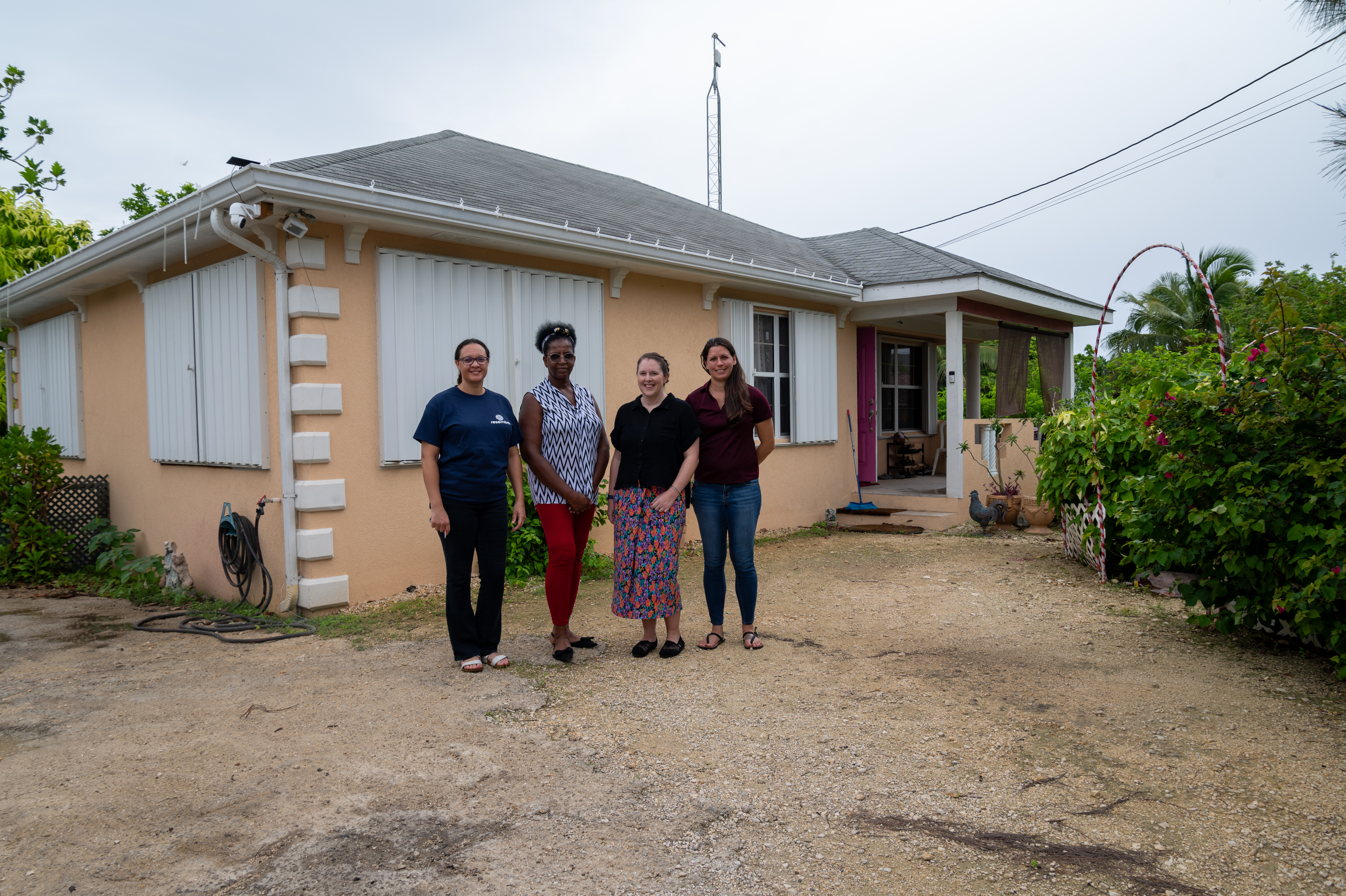 Image of Cayman Islands Government Civil Servant standing with resident infront of her house after improvments to make it more affordable and energy efficient