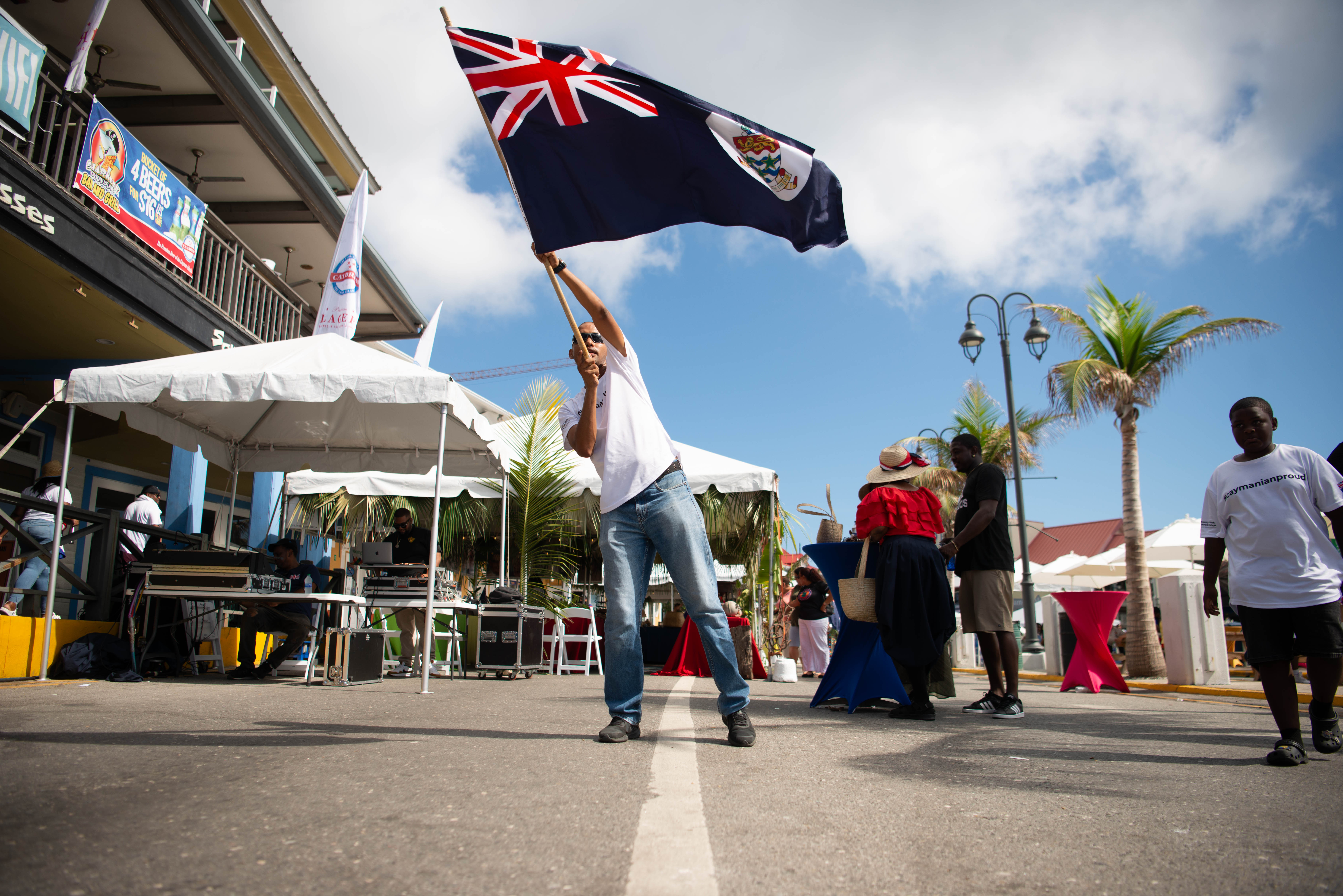 Man waving Cayman Islands flag as part of Emancipation day in the Cayman Islands 2025