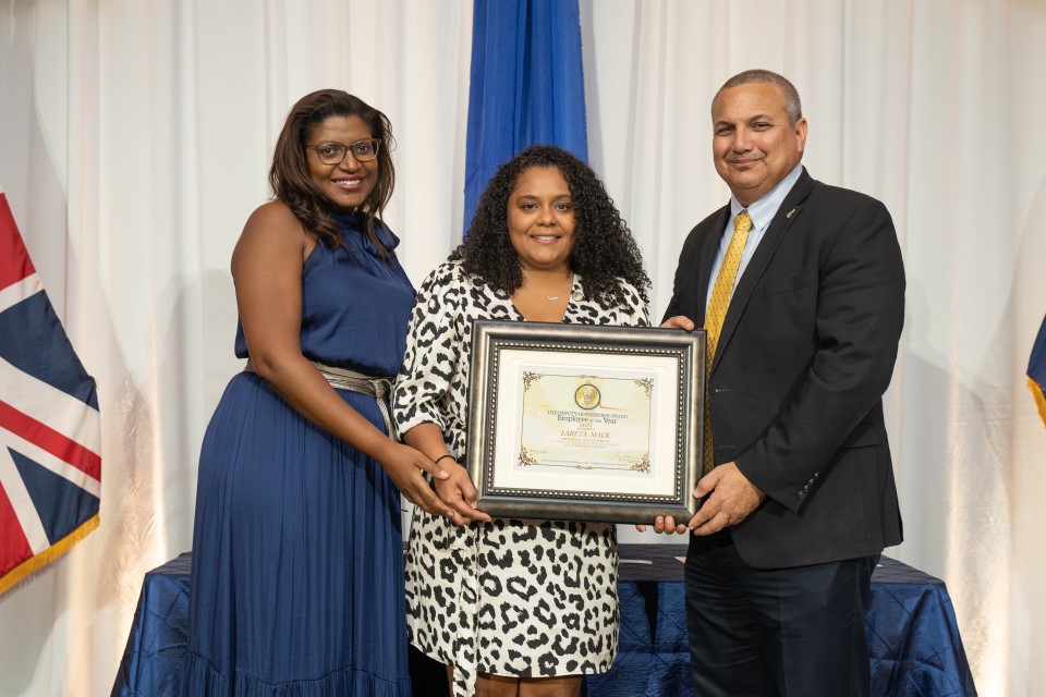 Employee of the Year Lareta Mack receives award from Deputy Governor Hon. Franz Manderson and POCS Chief Officer Gloria McField-Nixon