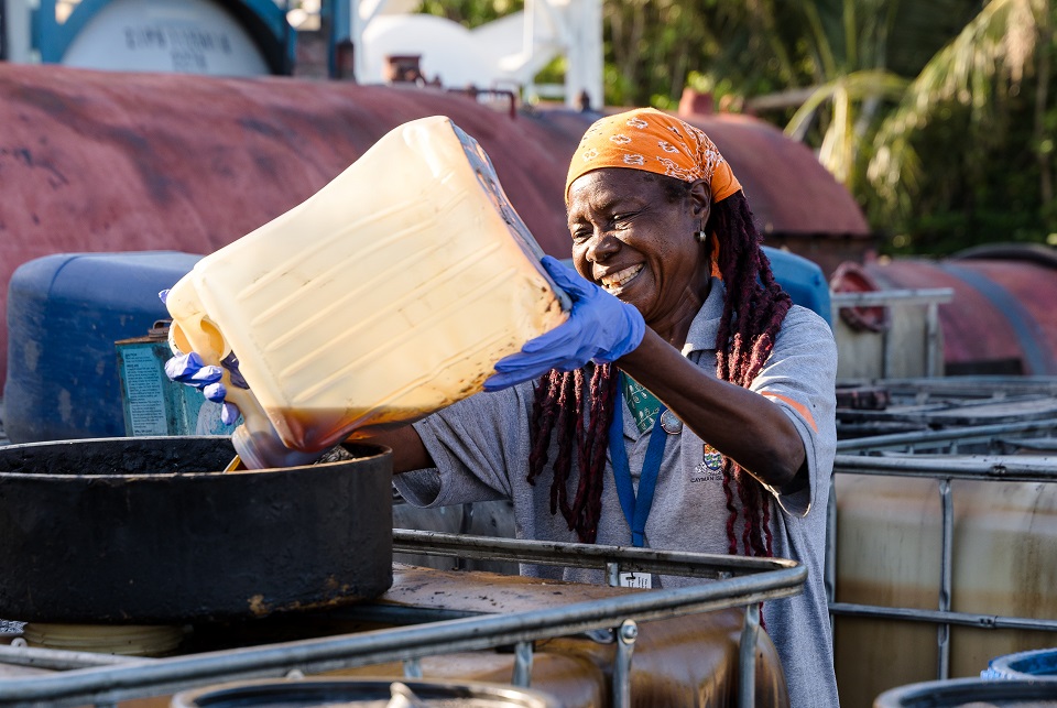 Cayman Islands Government Civil Servant carefully deposes of oil safely.